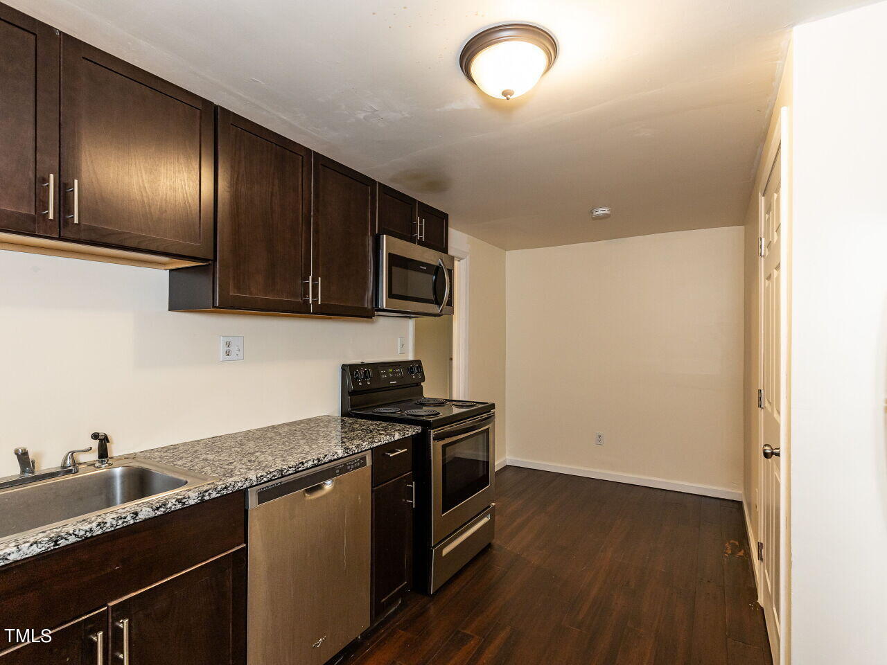 7 Ratcale Lane Durham, NC 27705 - Photo 25 of 33 a kitchen with granite countertop stainless steel appliances and wooden cabinets