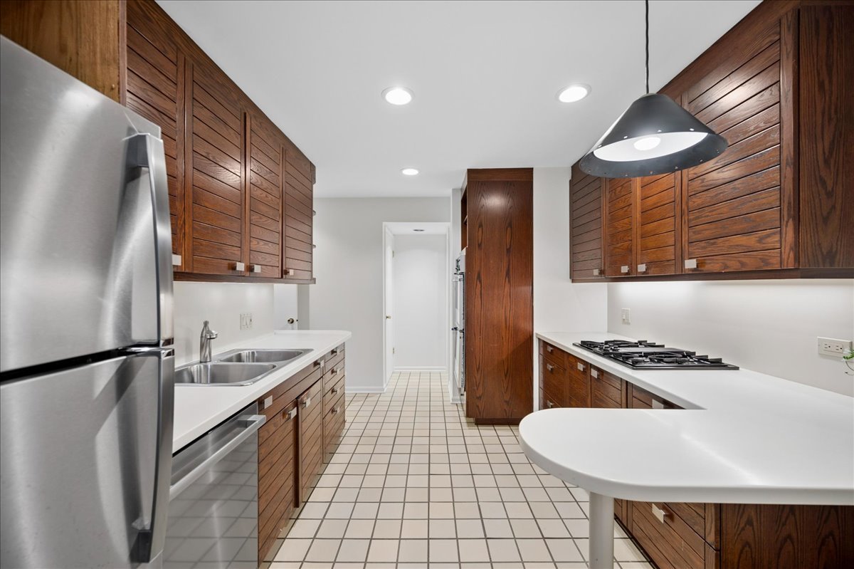 1701 Colonial Lane Northfield, IL 60093 - Photo 8 of 20 a kitchen with stainless steel appliances granite countertop a sink stove and refrigerator
