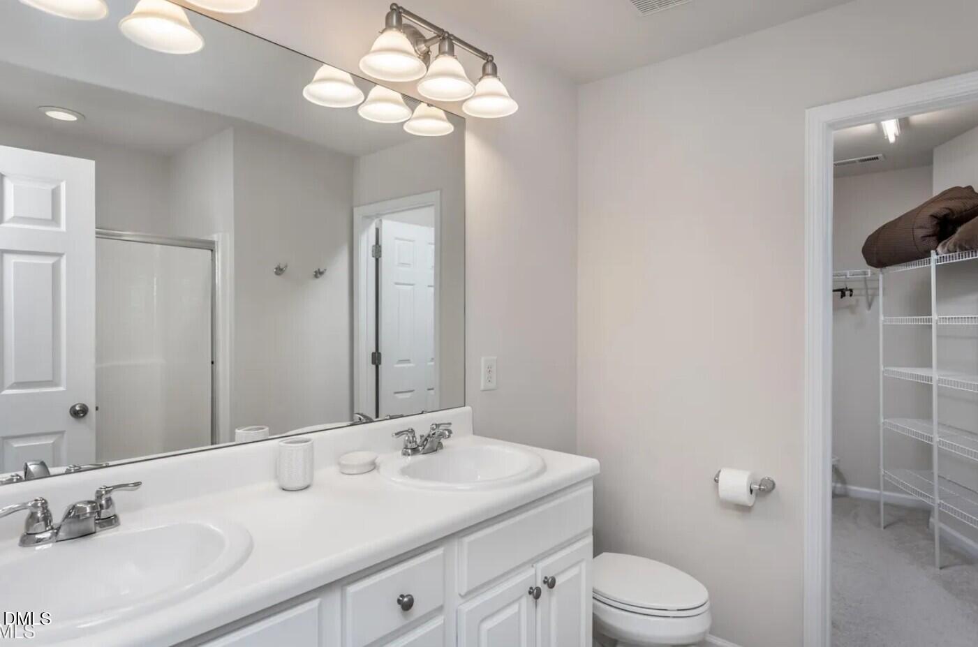 7031 Racine Way Raleigh, NC 27615 - Photo 19 of 24 a bathroom with a toilet a sink and mirror