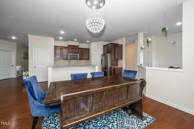 a kitchen with stainless steel appliances granite countertop a sink a stove a refrigerator cabinets and living room view