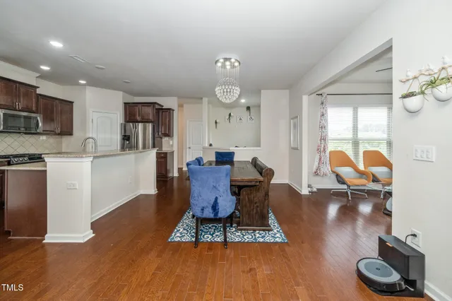 a living room with furniture a flat screen tv and kitchen view