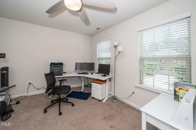 a view of a workspace with furniture and a window