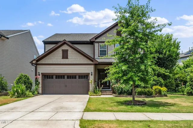 a front view of a house with a yard and garage