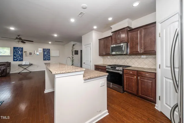 a kitchen with stainless steel appliances granite countertop a refrigerator stove microwave and sink
