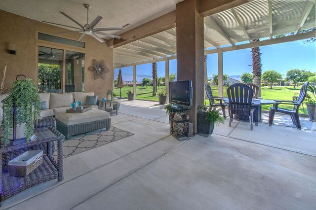 a living room with patio furniture and a large window