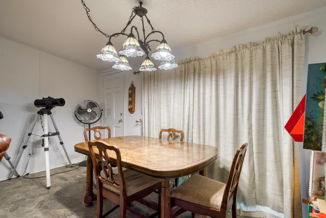 a view of a dining room with furniture and chandelier