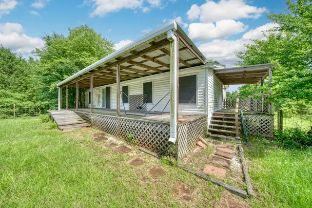 a view of a house with a small yard and wooden fence