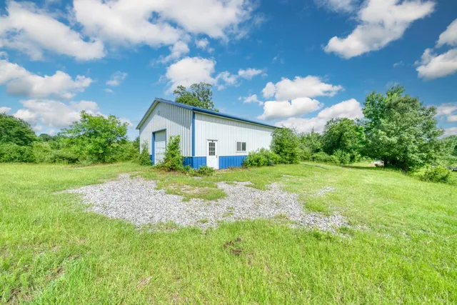 a view of a house with a backyard and a forest