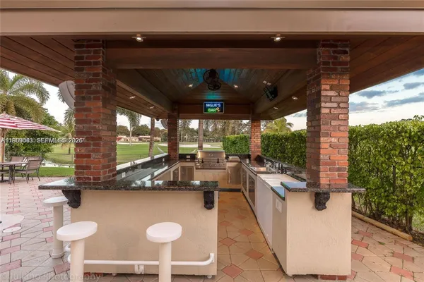 a view of a patio with chairs and a grill