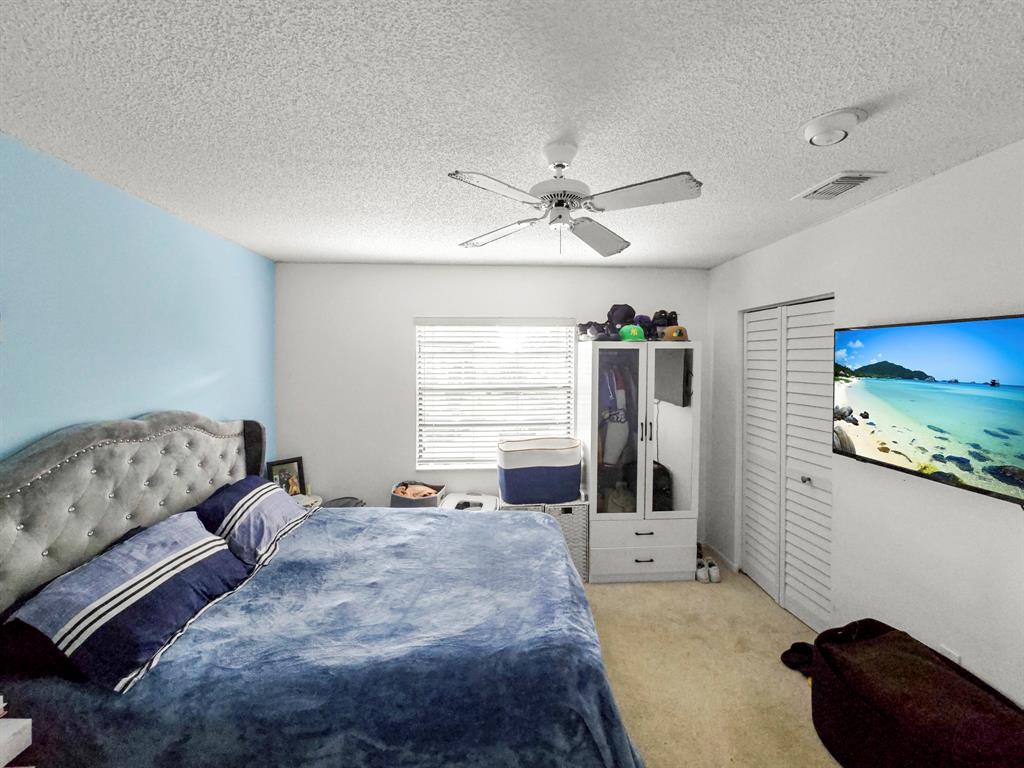 9286 Vista Del Lago, Unit 35B Boca Raton, FL 33428 - Photo 11 of 17 a bedroom with a bed window and a chandelier