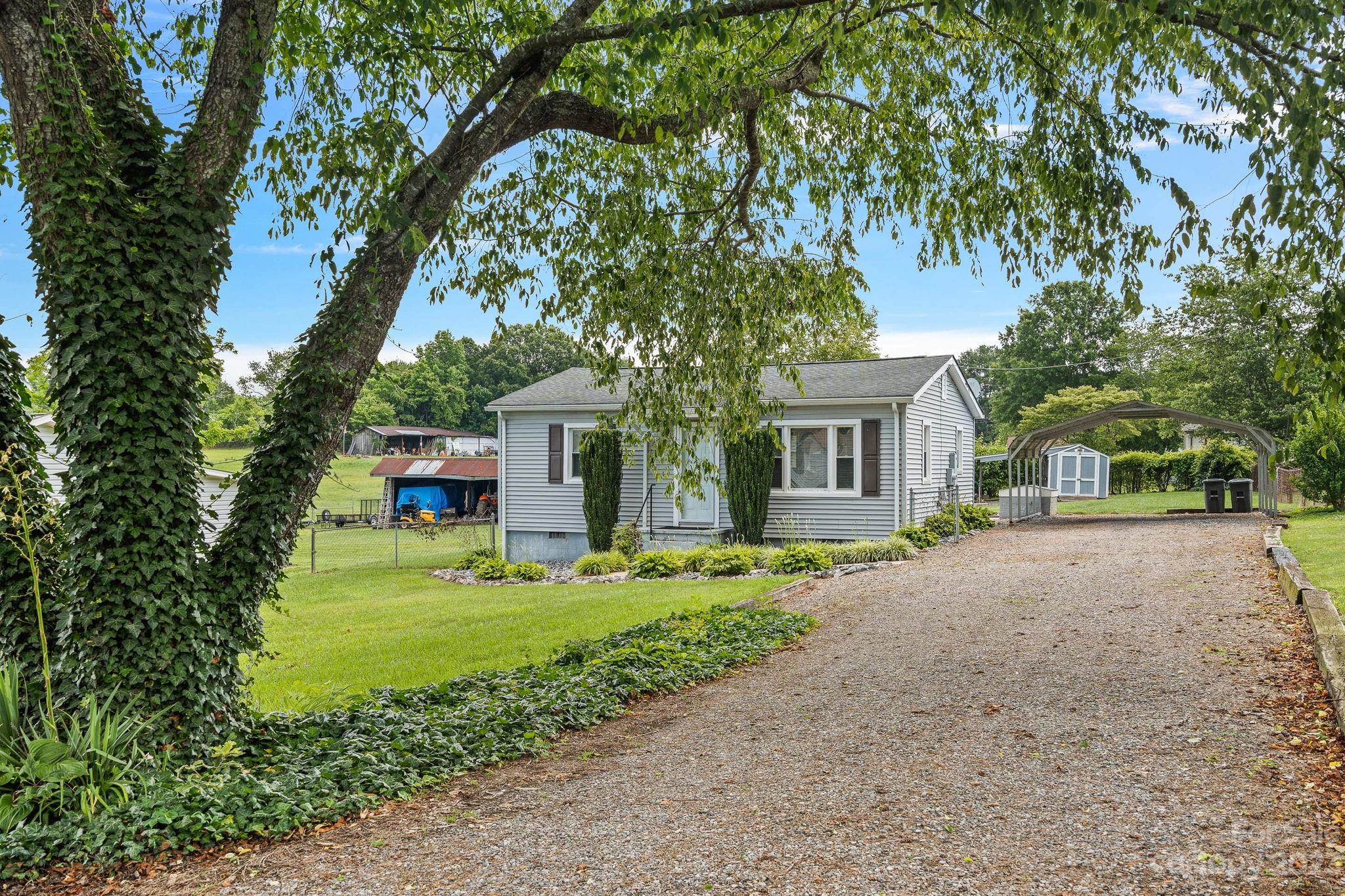 825 Reynolds Road Statesville, NC 28677 - Photo 25 of 26 a front view of a house with a garden and trees
