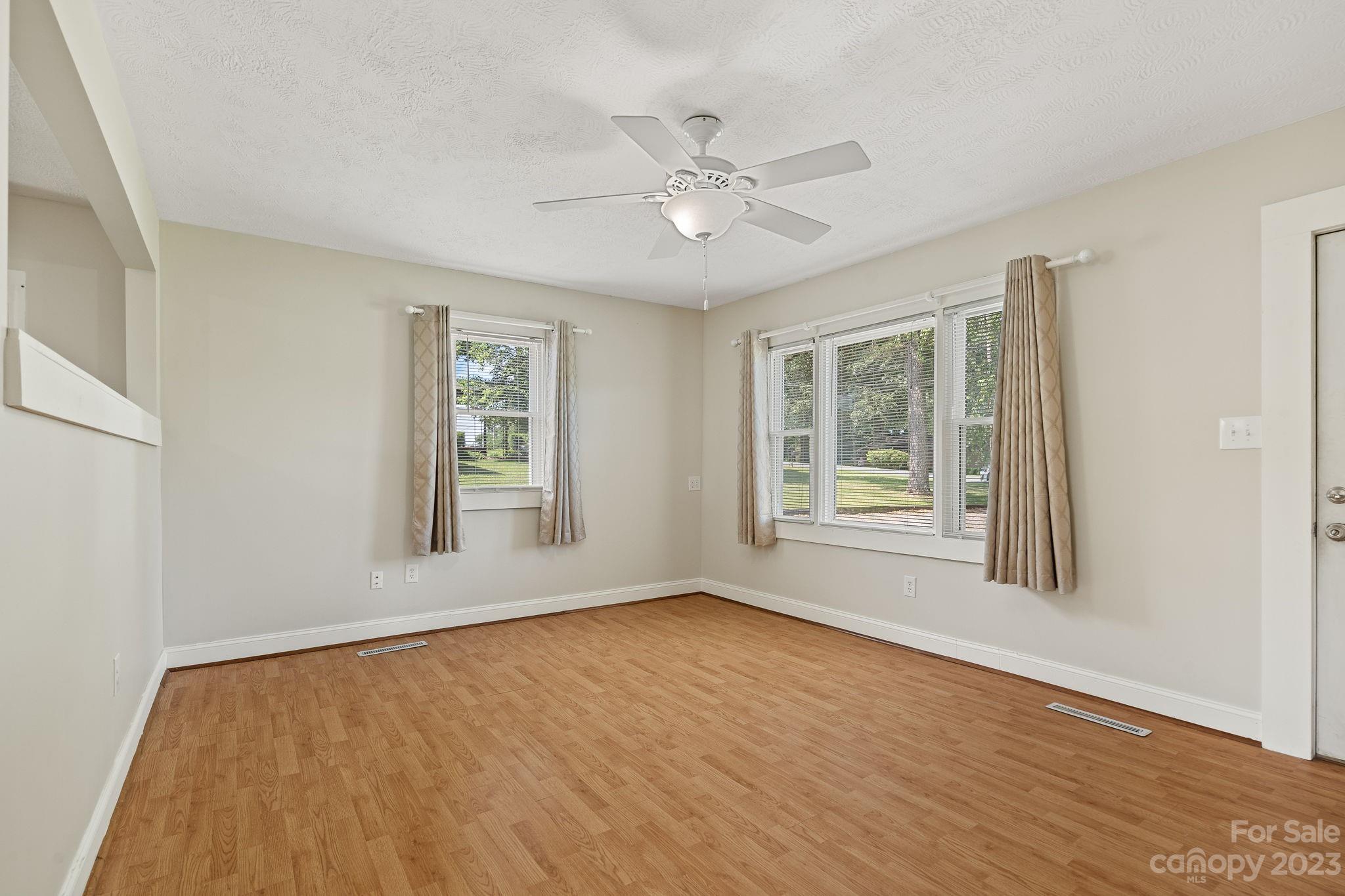 825 Reynolds Road Statesville, NC 28677 - Photo 7 of 26 a view of an empty room with a window and wooden floor