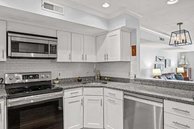 a kitchen with cabinets stainless steel appliances and sink