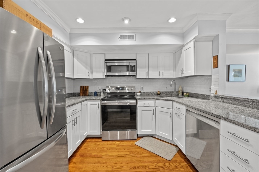 27 R West Street, Unit 4 Beverly, MA 01915 - Photo 4 of 27 a kitchen with stainless steel appliances granite countertop a stove a sink and a refrigerator