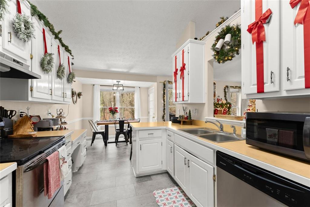 2980 Phillips Bend Crossing Northeast Buford, GA 30519 - Photo 11 of 45 a kitchen with a stove a sink and cabinets