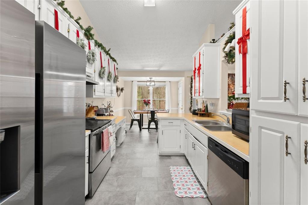 2980 Phillips Bend Crossing Northeast Buford, GA 30519 - Photo 12 of 45 a kitchen with stainless steel appliances granite countertop a barbecue grill and a refrigerator