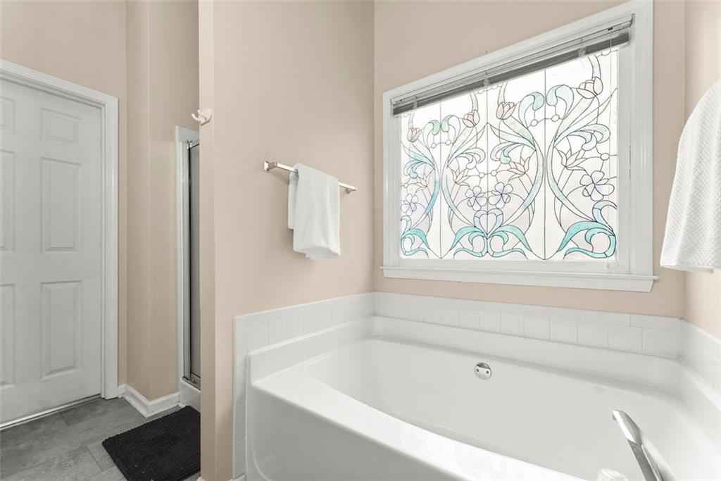 2980 Phillips Bend Crossing Northeast Buford, GA 30519 - Photo 20 of 45 a bathroom with a bathtub and window
