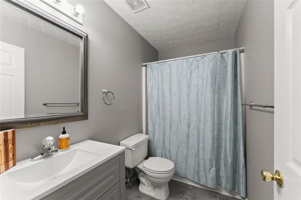 2980 Phillips Bend Crossing Northeast Buford, GA 30519 - Photo 27 of 45 a bathroom with a sink a toilet and shower curtain