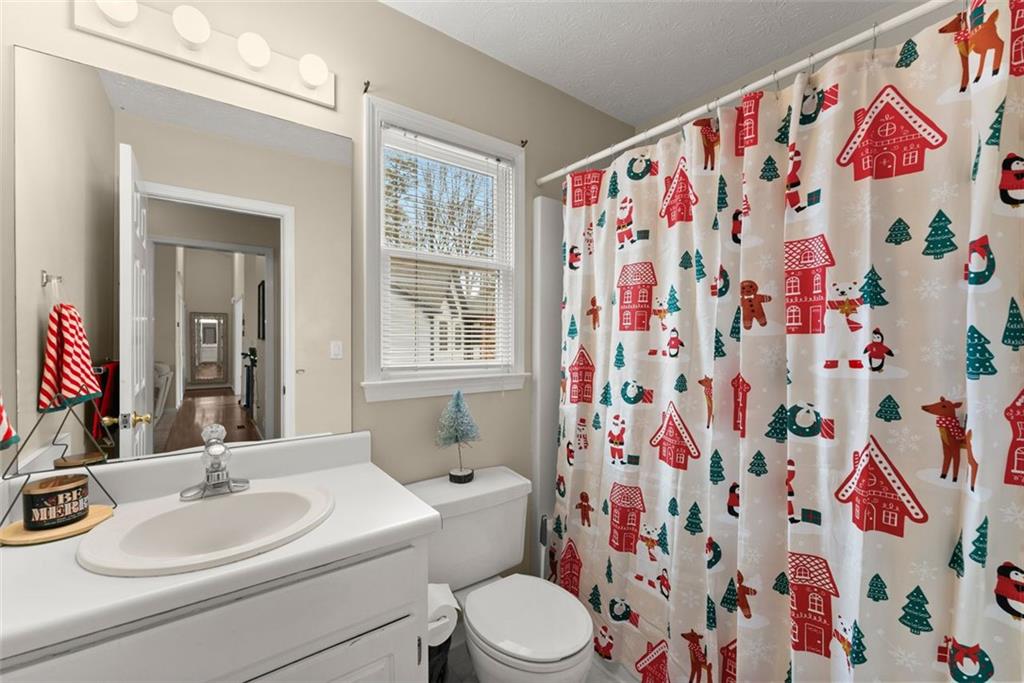 2980 Phillips Bend Crossing Northeast Buford, GA 30519 - Photo 30 of 45 a bathroom with a sink toilet and shower curtain
