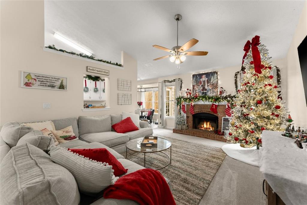 2980 Phillips Bend Crossing Northeast Buford, GA 30519 - Photo 6 of 45 a living room with furniture a fireplace and a chandelier