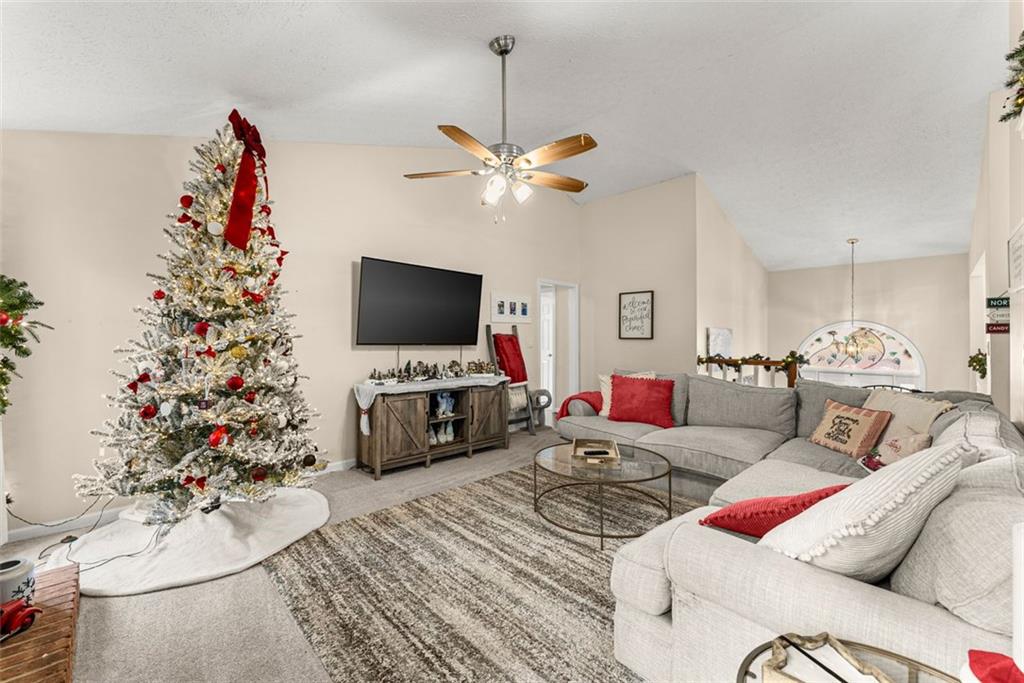 2980 Phillips Bend Crossing Northeast Buford, GA 30519 - Photo 7 of 45 a living room with furniture a chandelier and a flat screen tv