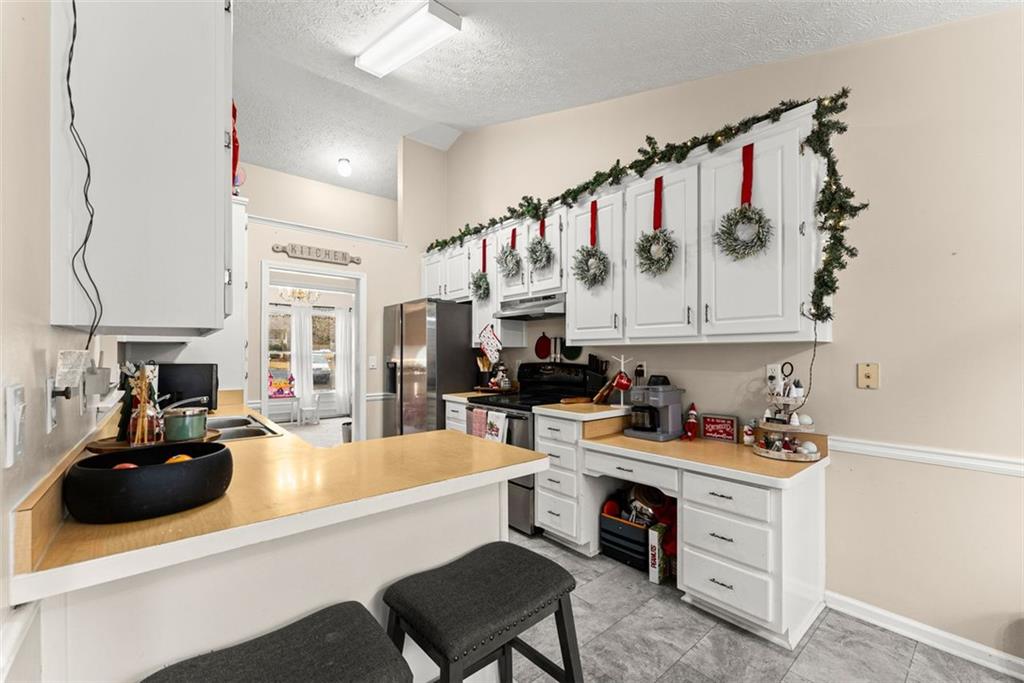 2980 Phillips Bend Crossing Northeast Buford, GA 30519 - Photo 10 of 45 a kitchen with a refrigerator and white cabinets