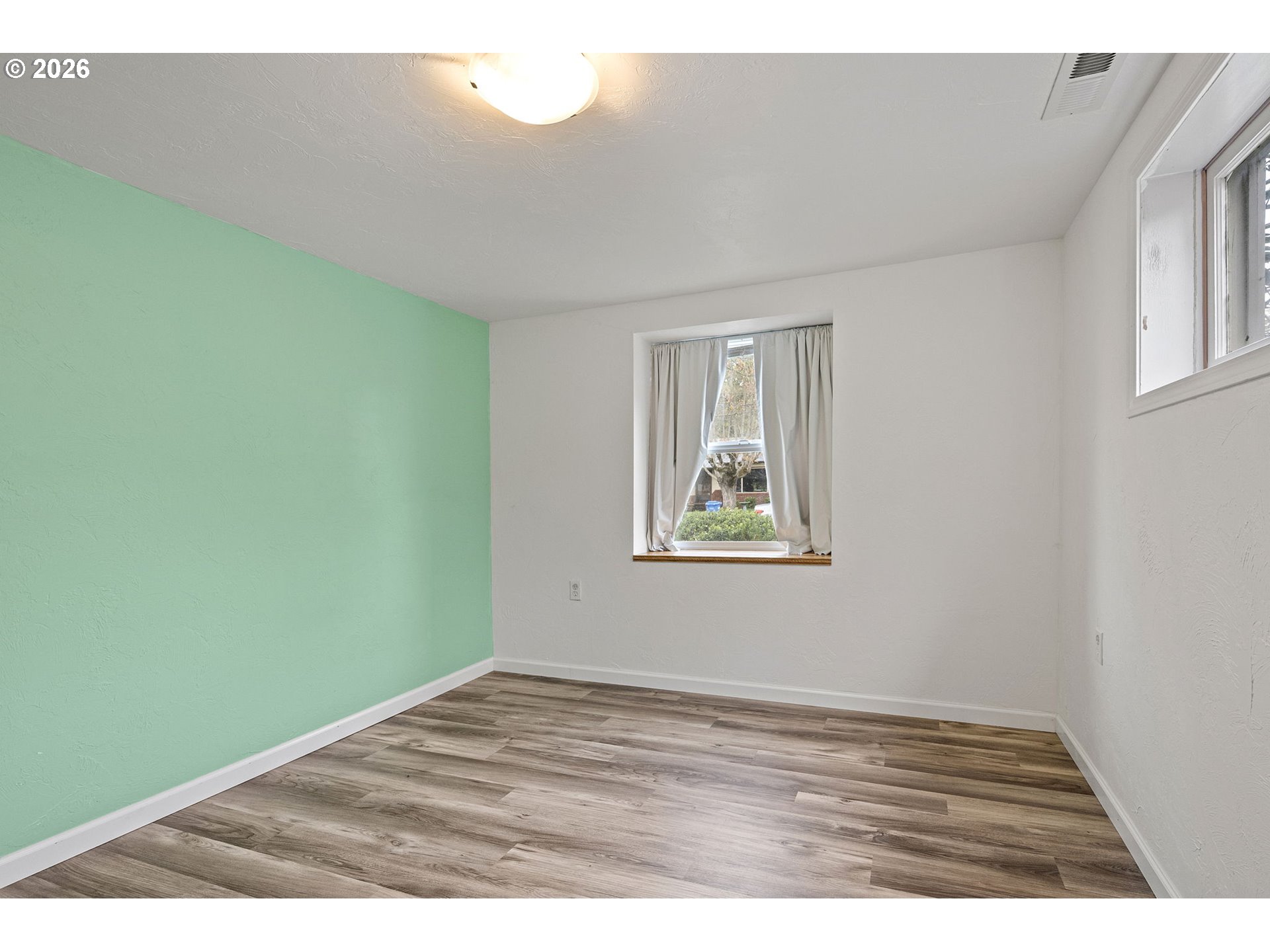 1565 Linwood Street Eugene, OR 97404 - Photo 16 of 42 a view of an empty room with wooden floor and a window