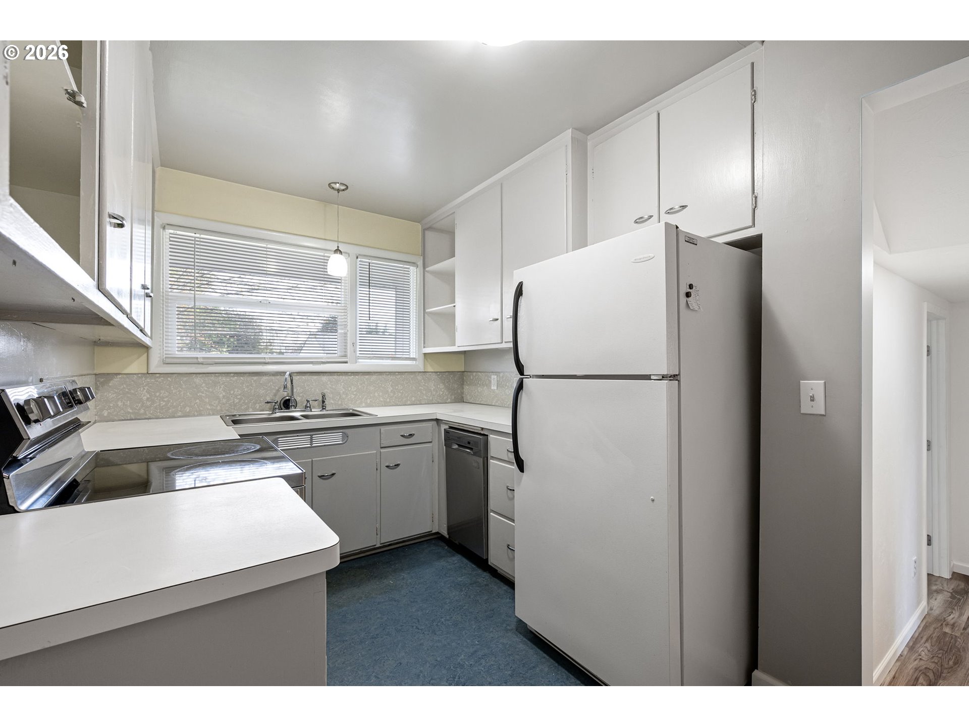 1565 Linwood Street Eugene, OR 97404 - Photo 10 of 42 a kitchen with a refrigerator a sink and cabinets