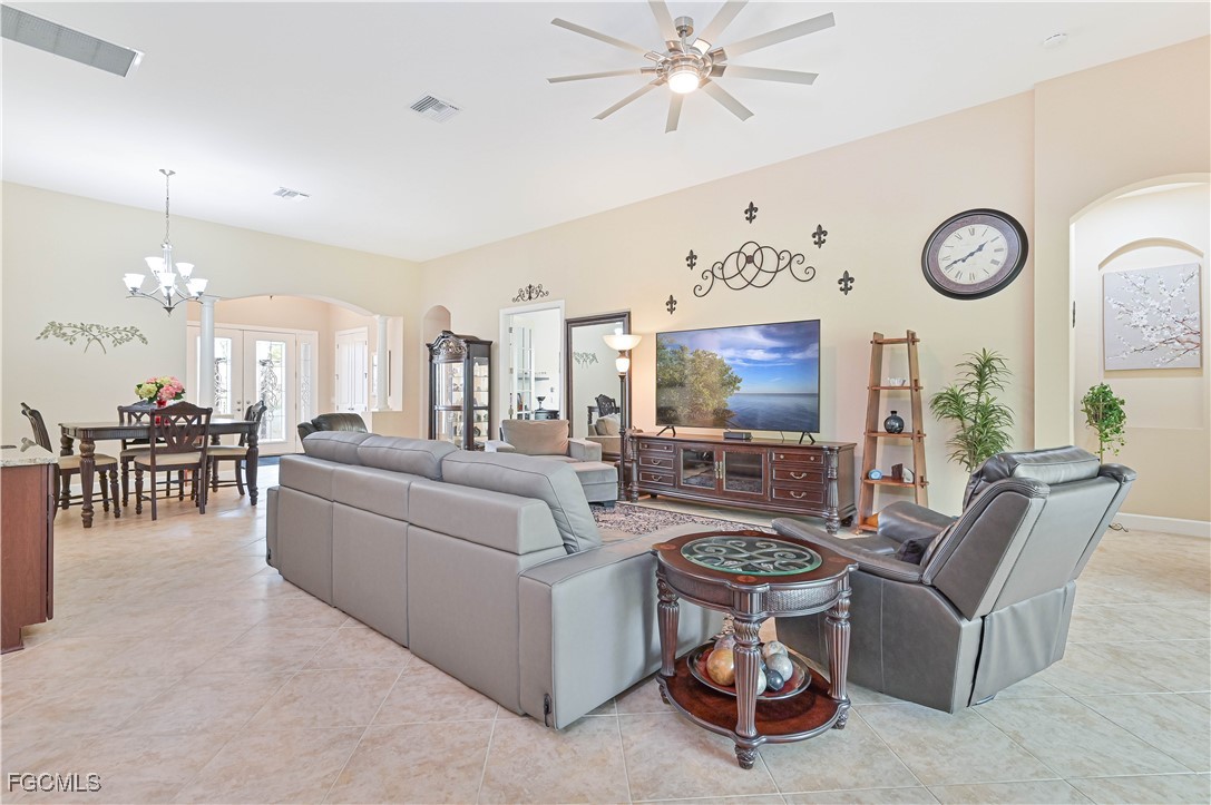17283 Walnut Run Drive Alva, FL 33920 - Photo 13 of 49 a living room with furniture a clock and a chandelier