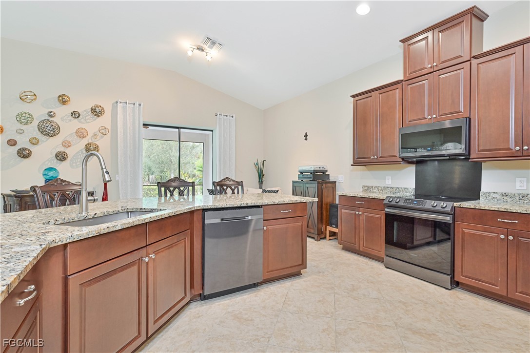 17283 Walnut Run Drive Alva, FL 33920 - Photo 23 of 49 a kitchen with stainless steel appliances granite countertop a sink stove and refrigerator