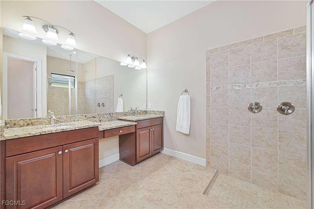 17283 Walnut Run Drive Alva, FL 33920 - Photo 30 of 49 a bathroom with a granite countertop sink a toilet a mirror and shower