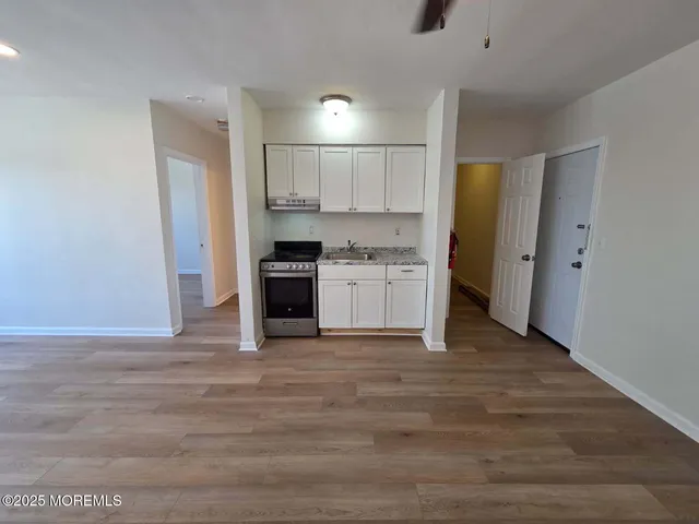 a view of kitchen with stainless steel appliances granite countertop a stove top oven a refrigerator and a sink