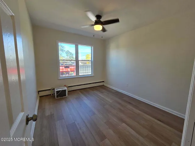 an empty room with windows and fan