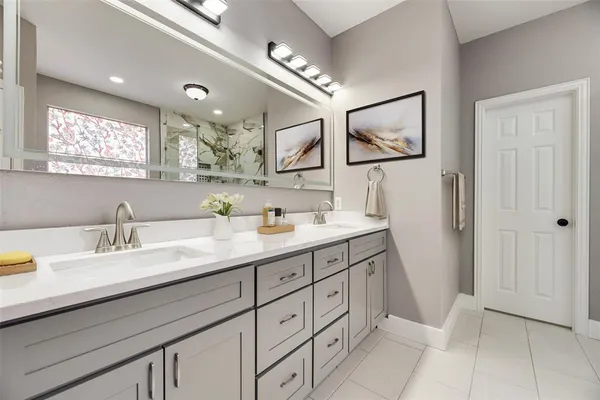 a spacious bathroom with a double vanity sink a mirror and a