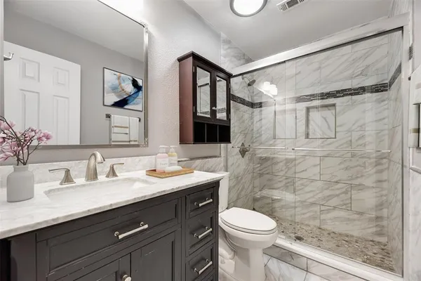 a bathroom with a sink a toilet and shower