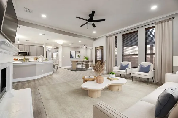 a living room with furniture kitchen view and a large window