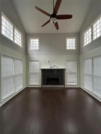 an empty room with windows and fireplace