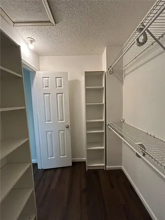 a view of walk in closet with empty racks