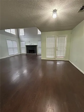 an empty room with wooden floor and fireplace