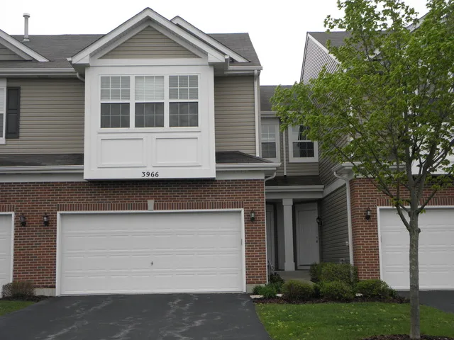 a front view of a house with a garden and garage