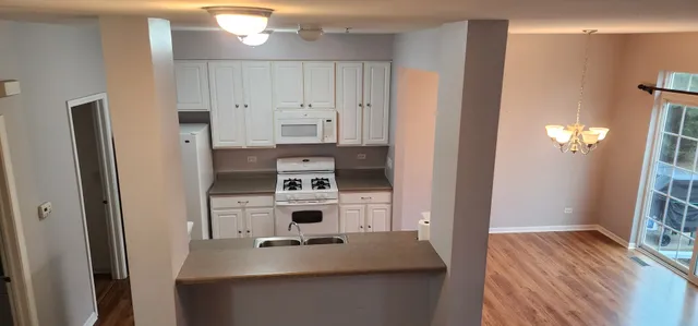 a kitchen with white cabinets and appliances