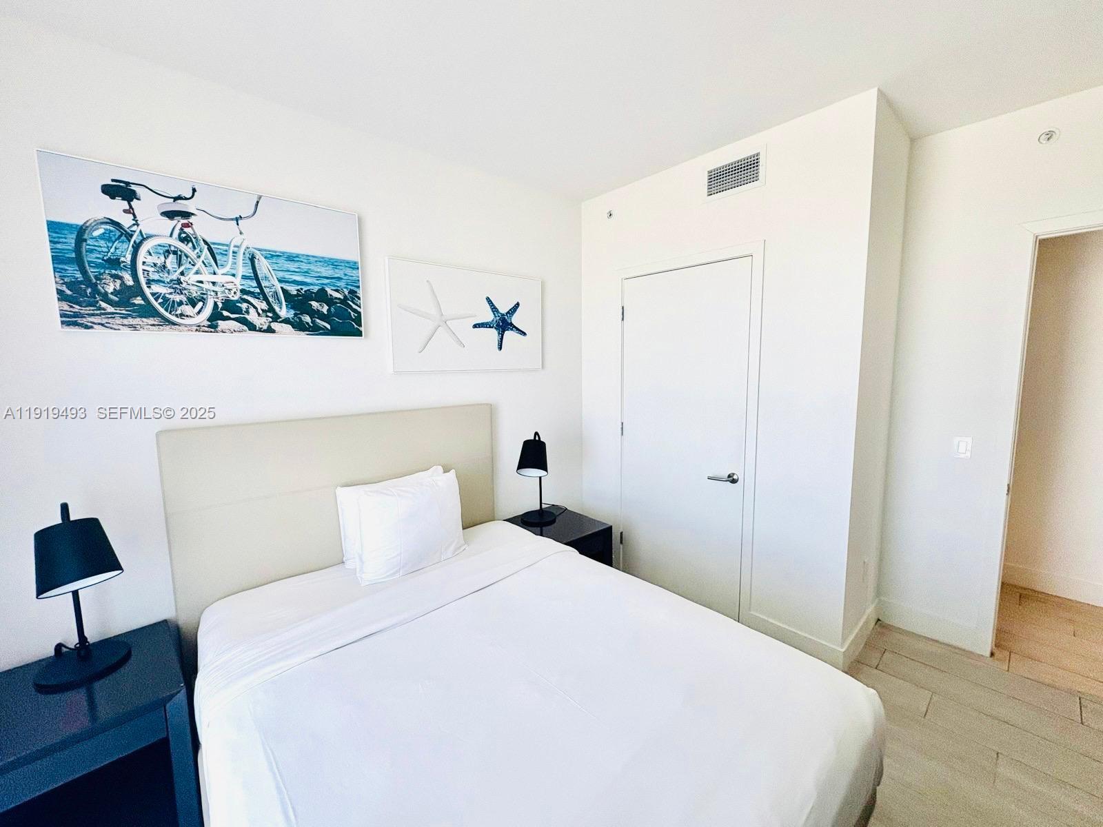 4010 South Ocean Drive, Unit R2904 Hollywood, FL 33019 - Photo 13 of 32 a bedroom with a bed and a lamp on table