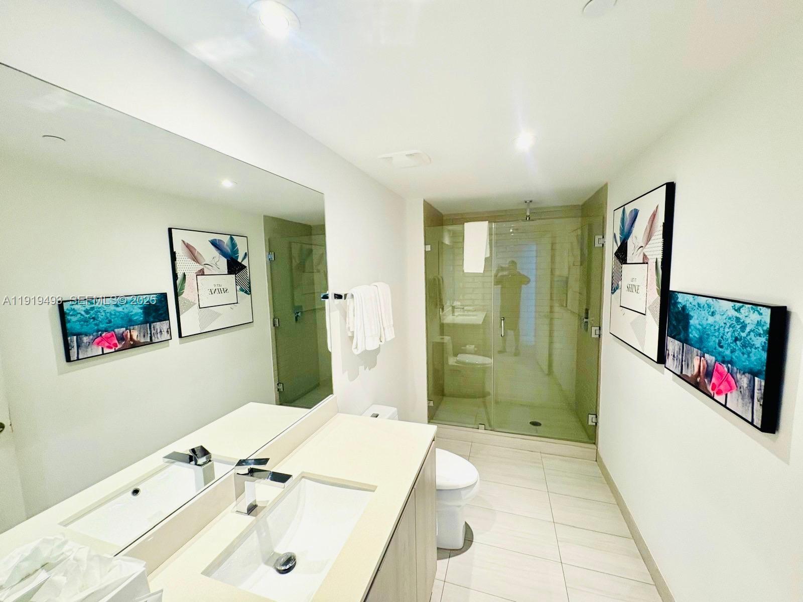 4010 South Ocean Drive, Unit R2904 Hollywood, FL 33019 - Photo 16 of 32 a bathroom with a sink mirror and a shower