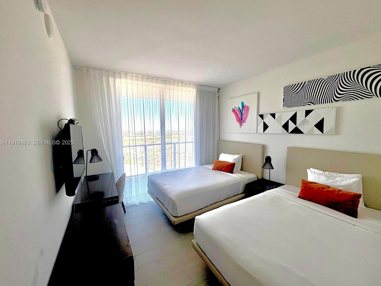 4010 South Ocean Drive, Unit R2904 Hollywood, FL 33019 - Photo 17 of 32 a bedroom with two beds and a large window