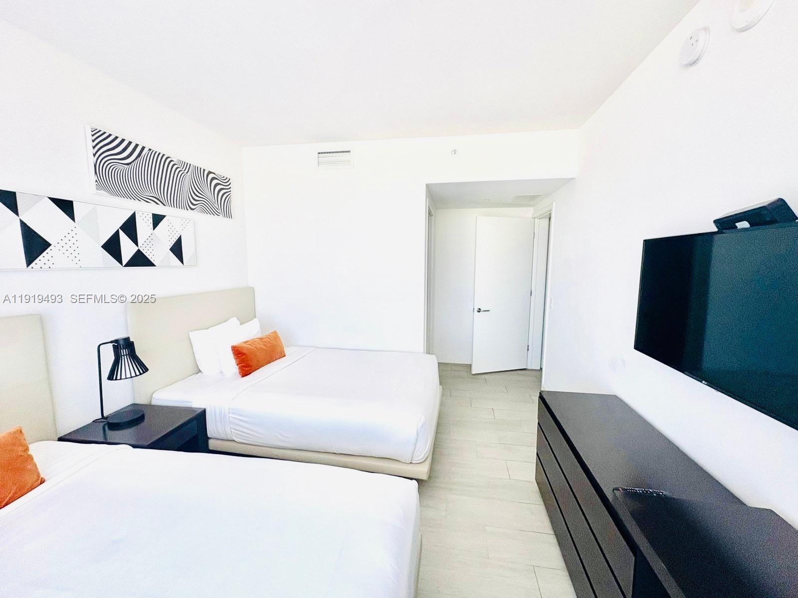 4010 South Ocean Drive, Unit R2904 Hollywood, FL 33019 - Photo 18 of 32 a bedroom with a bed and a book shelf