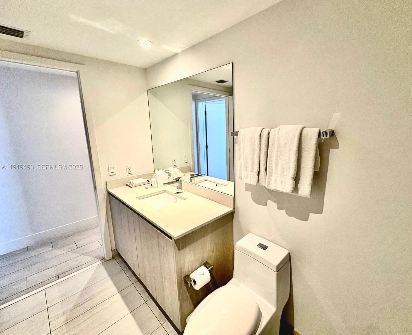 4010 South Ocean Drive, Unit R2904 Hollywood, FL 33019 - Photo 19 of 32 a bathroom with a sink a mirror and a toilet