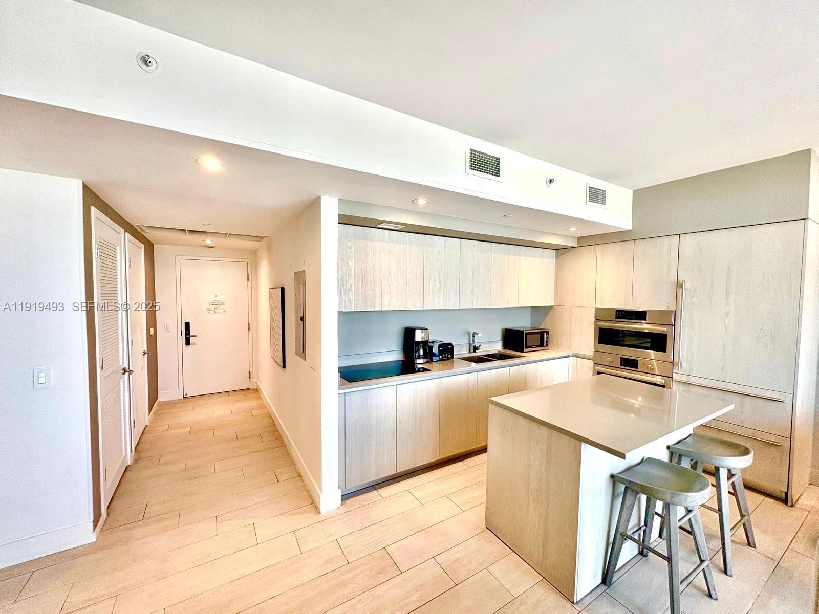 4010 South Ocean Drive, Unit R2904 Hollywood, FL 33019 - Photo 4 of 32 a kitchen with white cabinets and white appliances