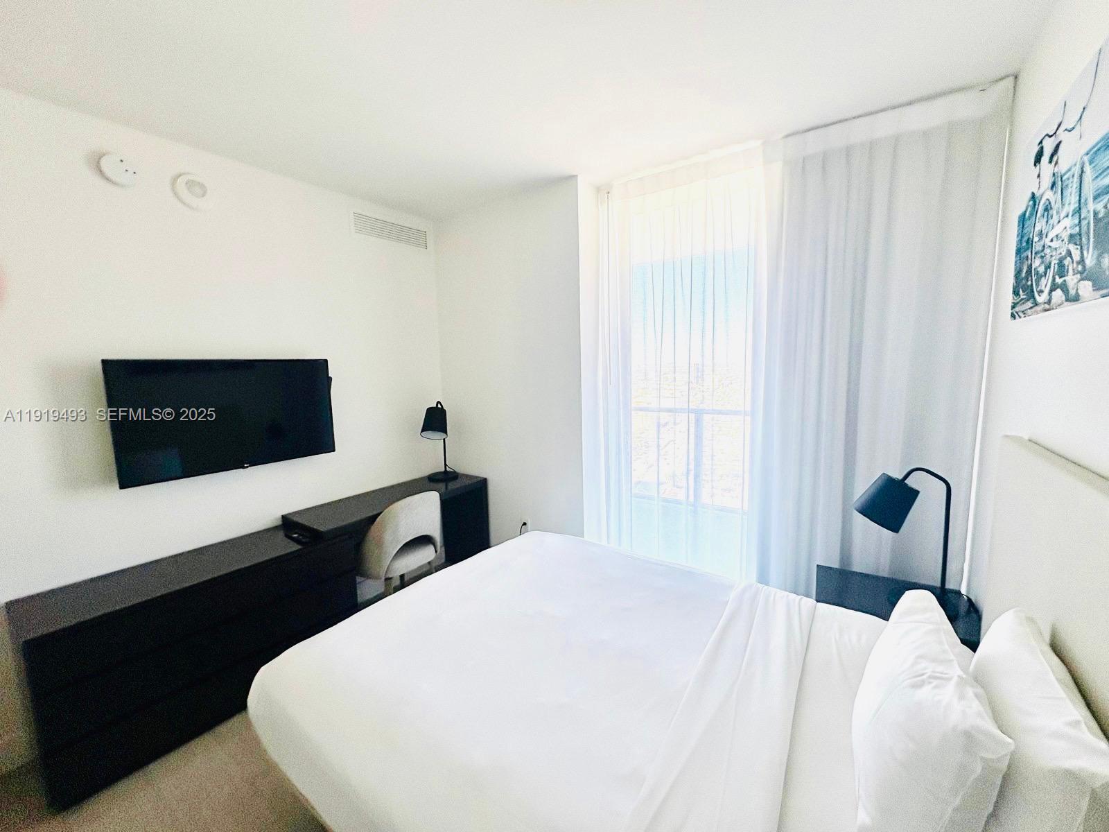 4010 South Ocean Drive, Unit R2904 Hollywood, FL 33019 - Photo 6 of 32 a bedroom with a bed and a flat screen tv