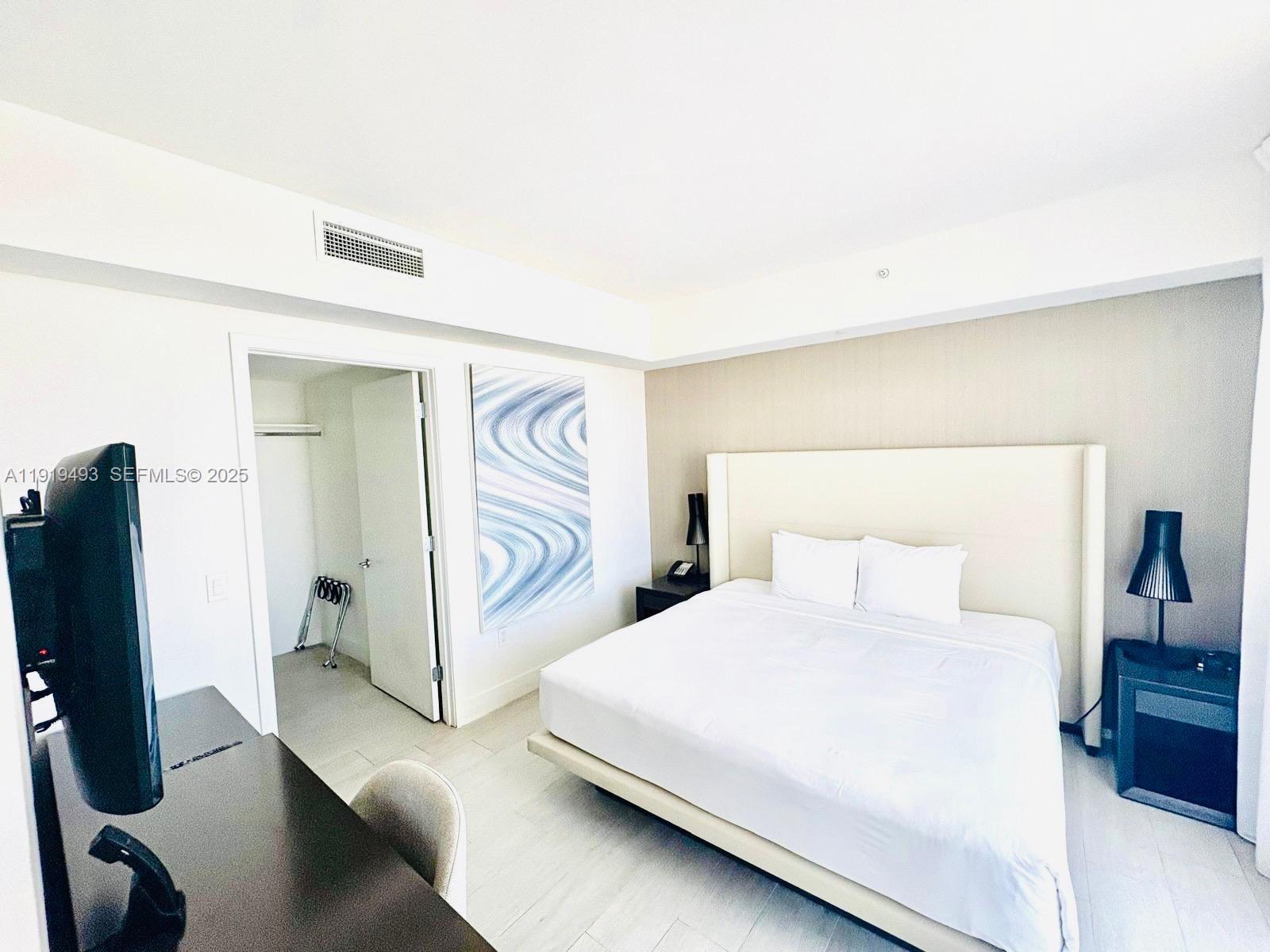 4010 South Ocean Drive, Unit R2904 Hollywood, FL 33019 - Photo 9 of 32 a bedroom with a bed and a flat tv screen on the dresser