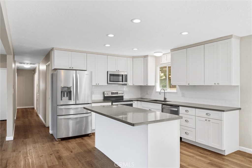 904 Long Bar Road Oroville, CA 95966 - Photo 15 of 50 a kitchen with cabinets stainless steel appliances and wooden floor
